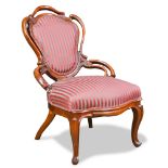 American Rococo Revival walnut parlor chair, having a pierced shield form back and rising on
