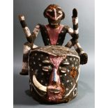 A Vanuatu head or helmet mask, Namba people, Malekula, with a figure on back-top, clay over fiber,