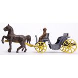 Polychrome metal toy horse driven carriage with driver