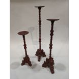 (lot of 3) A group of Spanish Colonial style candlesticks, each executed in metal with crimson