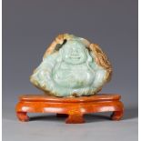 A carved hardstone figure of buddha, a seated Buddha with apple-green and russet coloration,