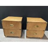 Pair of Baker campaign style night stands, each having a rectangular top, above a hinged door,