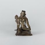 A bronze sculpture of Buddha, Seated on a shaped base, with the right leg pendent, the face in a