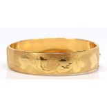 18k yellow gold bracelet The foliate motif engraved and textured, 18k yellow gold, hinged bangle,