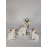 (lot of 3) Staffordshire spaniel figures, each executed in cream with gilt spots and painted
