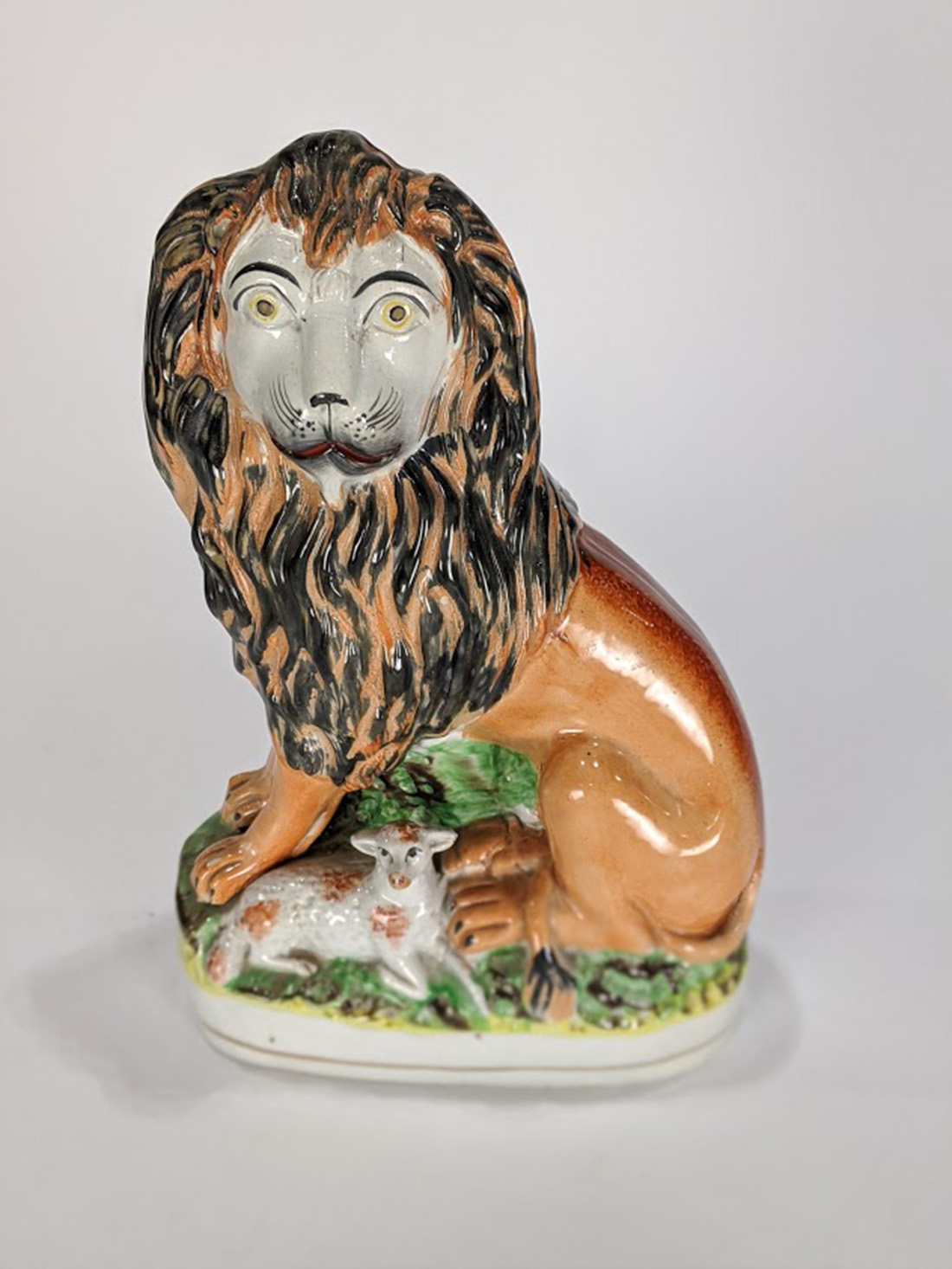 English Staffordshire figure of a lion and a lamb, the lion having a molded and painted body, 10.5"