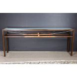 A contemporary glass and patinated metal console table, the frosted glass inset glass resting on the
