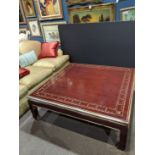 Chinese chinoiserie style red lacquered cocktail table, having a square top, with a gilt decorated