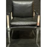 A Mies Van der Rohe style black leather and chrome armchair