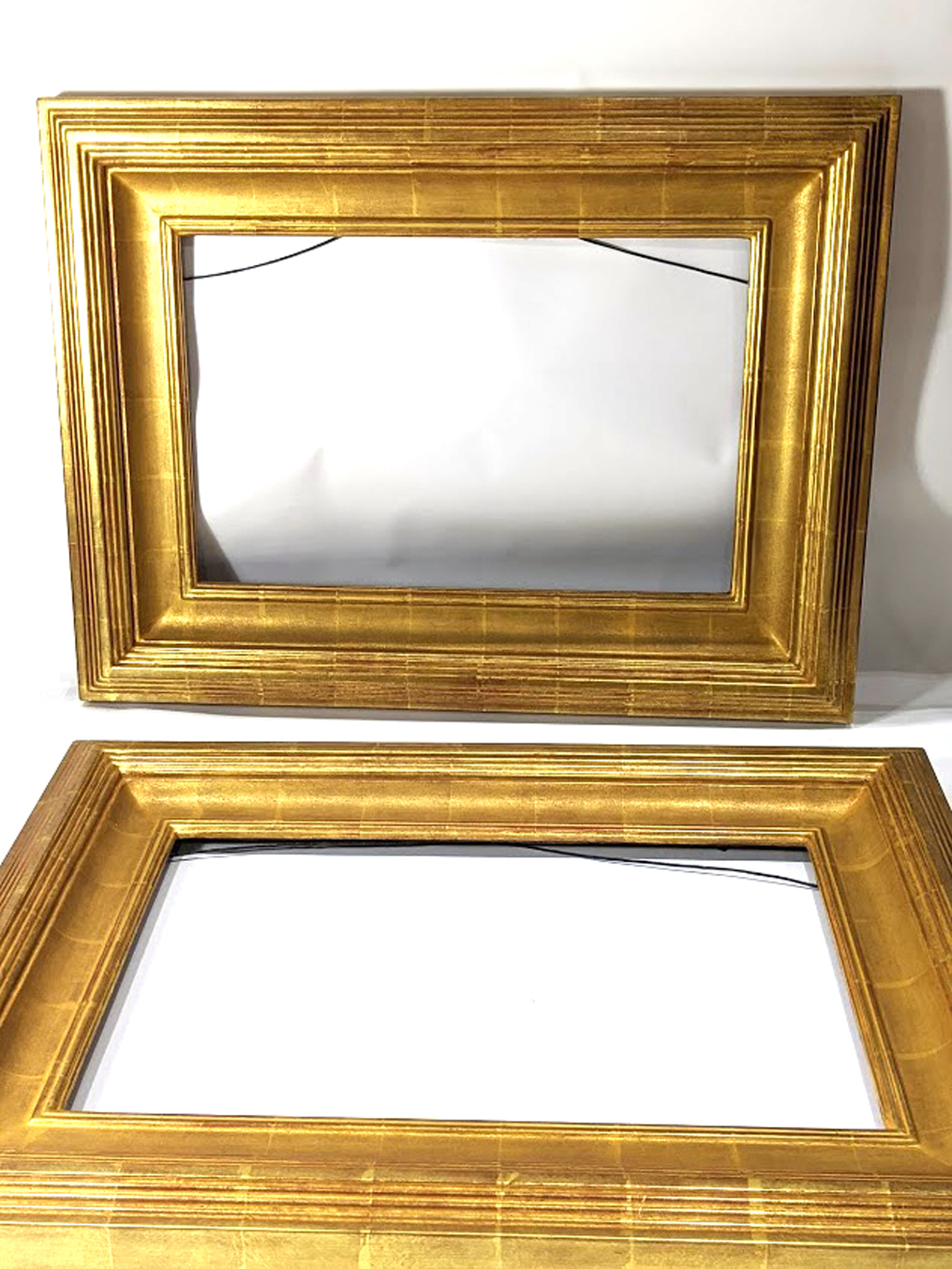 A pair of contemporary custom giltwood carved picture frames