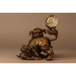 A Japanese Gilt Bronze Statue of Two Lions Holding a Crystal Ball