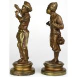 A matched pair of French patinated gilt metal figures