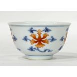 A Chinese iron red enameled, blue and white cup