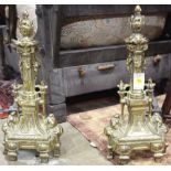 Continental gilt metal andirons. having a flame finial above the relief decorated body