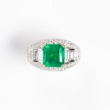 An emerald, diamond and eighteen karat white gold ring