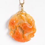 A carved orange jade and fourteen karat gold pendant necklace