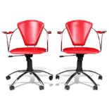 A pair of crimson leather swivel office chairs