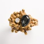 A synthetic black star sapphire, diamond and fourteen karat gold ring