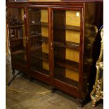 An Edwardian walnut sectional bookcase with glazed cabinet doors, in three sections, 56