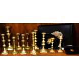 A collection of mostly brass candle sticks