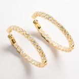 A pair of diamond and fourteen karat gold hoop earrings