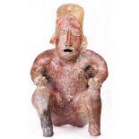 A Pre Columbian Jalisco seated red on buff clay figure