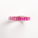 A ruby and fourteen karat gold band ring