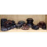 A shelf lot of Chinese wood vase stands and risers and a carved platform base for a bronze