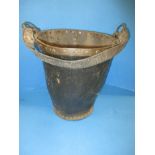 An antique leather bucket with copper trim