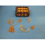 A quantity of yellow metal necklace chains in a quill box