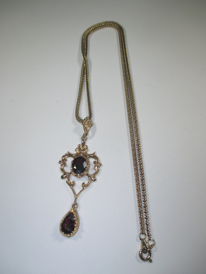 A gold pendant set with garnets with a 9ct fox tail chain, approx weight 10.9g