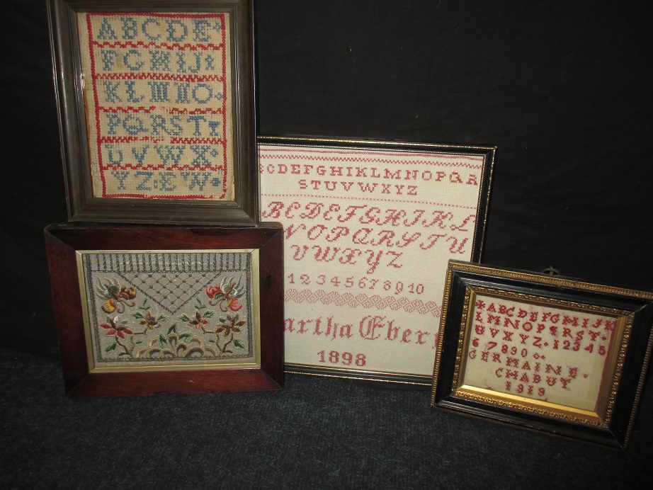 Four small samplers one on fine silk