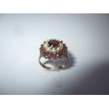 A 9ct gold garnet and seed pearl daisy ring, approx finger size N