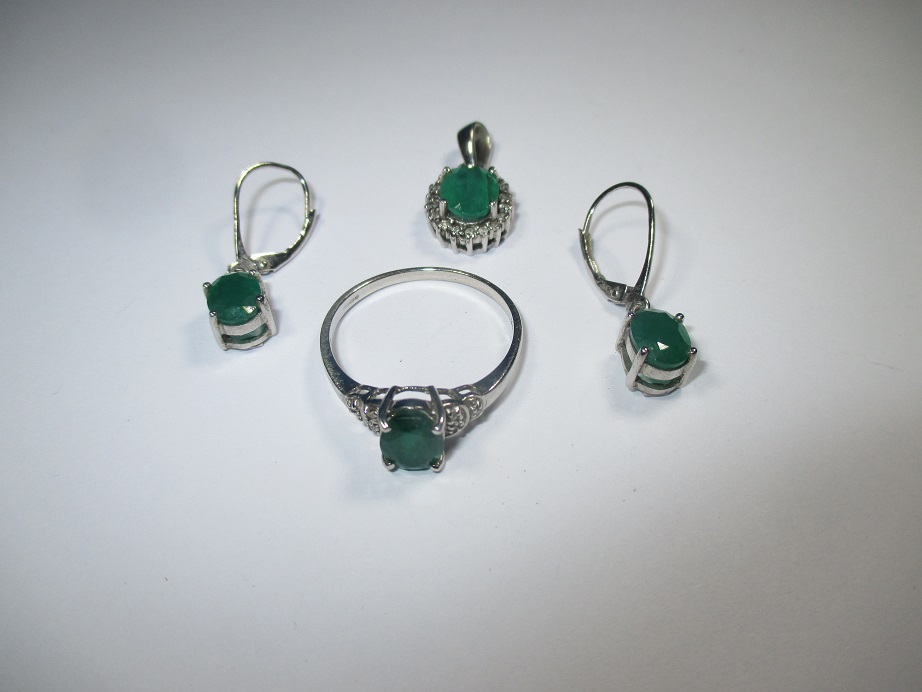 A ring, pendant and earrings all on 9ct white gold set with emeralds