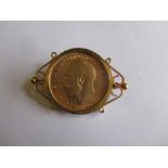 A 1911 gold full sovereign in a 9ct gold brooch mount