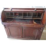 A 19th century roll top desk, having pull out writing surface and cupboard base