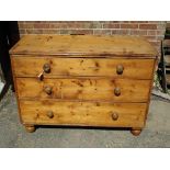 An antique stripped pine chest of 3 long drawers