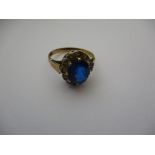 A 9ct gold ring with large central sapphire? surrounded by small diamonds, approx. ring size M1/2.