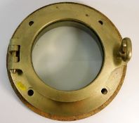 A brass ships porthole with back plate by Swinburn