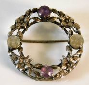 An antique silver brooch set with amethyst & carve