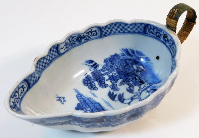 An 18thC. porcelain sauce boat with replacement ha