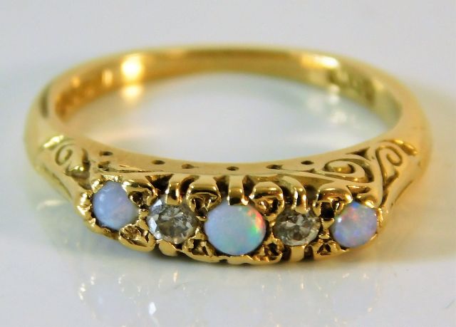 An 18ct gold ring set with opal & diamonds within