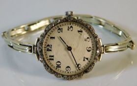 A platinum cased watch set with diamonds on a 9ct