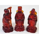 Three Chinese red amber style figures 3.75in tall
