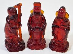 Three Chinese red amber style figures 3.75in tall