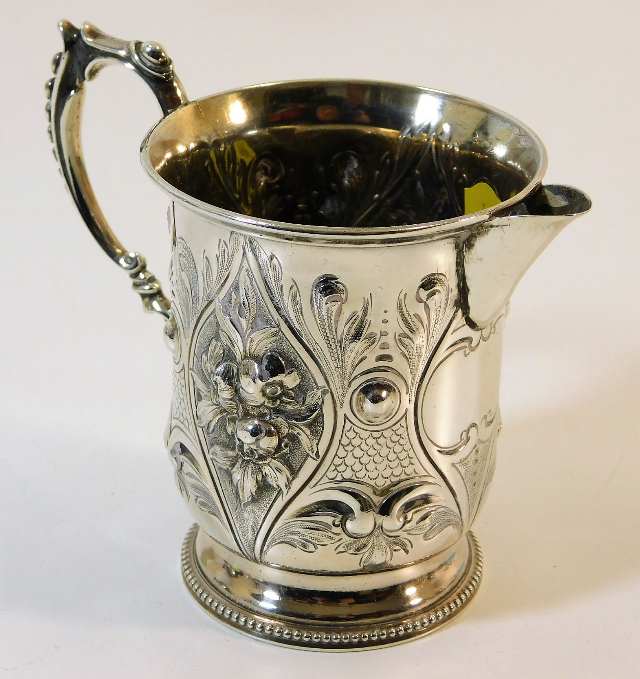 A Victorian silver cream jug with embossed decor G