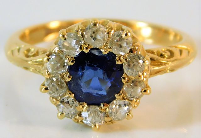 An antique 18ct gold sapphire ring with carved shoulder decor set with approx. 0.6ct old cut diamond