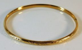 An 18ct gold bangle with chased decor 6.8g