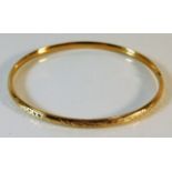 An 18ct gold bangle with chased decor 6.8g