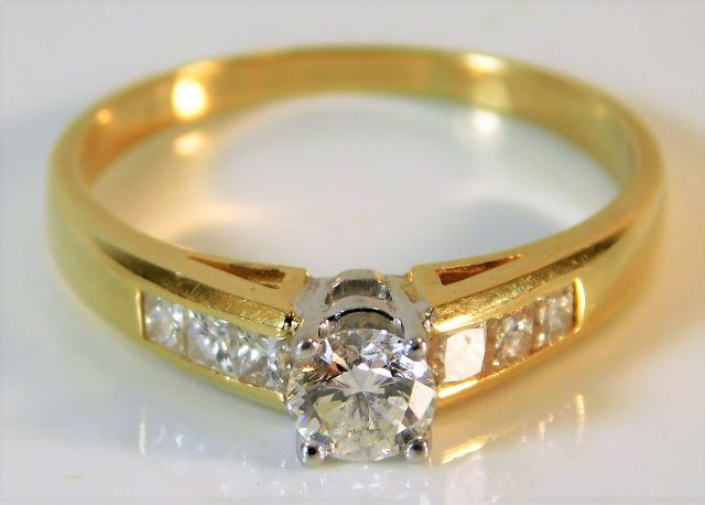 A yellow metal ring set with diamond, centre stone